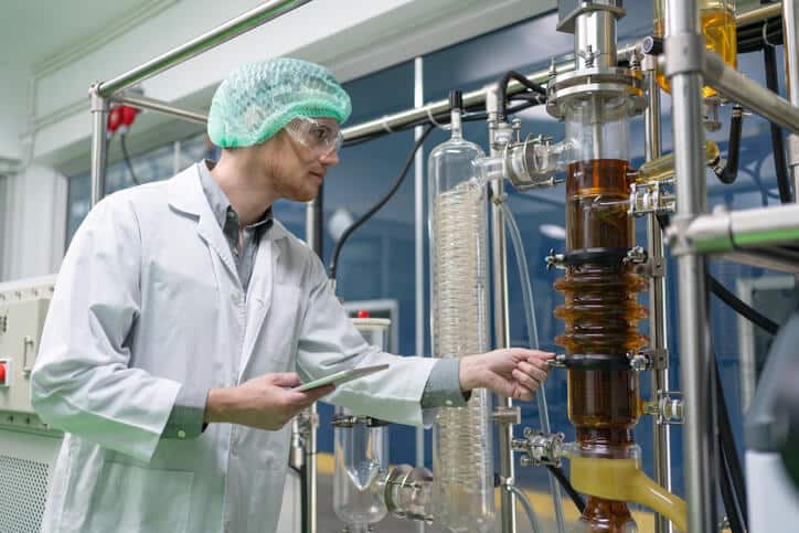 A cannabis extraction technician checking the extraction equipment during cannabis industry training