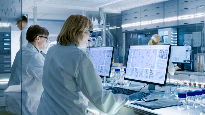 Male and female clinical research professionals analyzing big data in a laboratory after their clinical research training