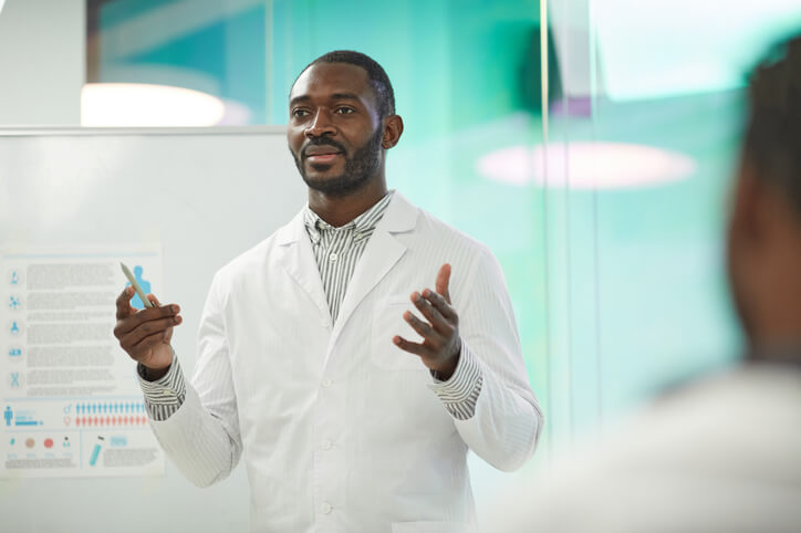 A male Medical Information Associate presenting research findings after completing his clinical research training