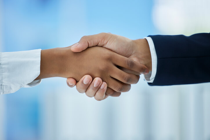 An image of two hands shaking representing a successful interview and job placement