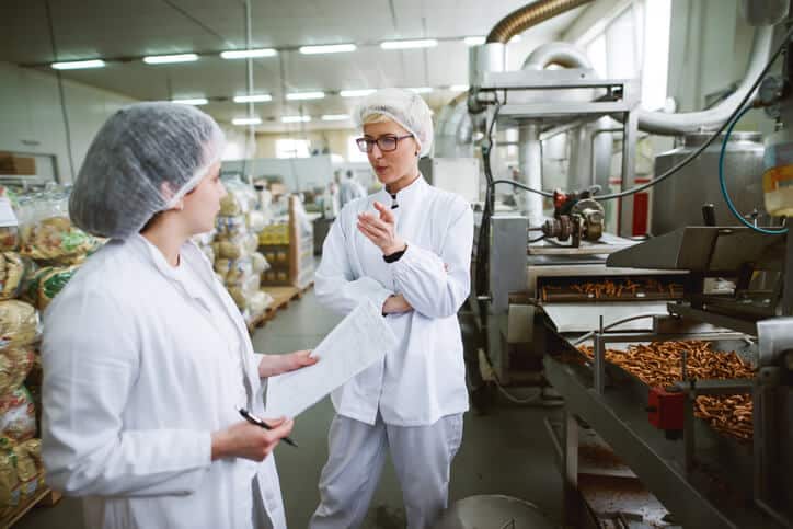 Two female food safety professionals at a food processing plant