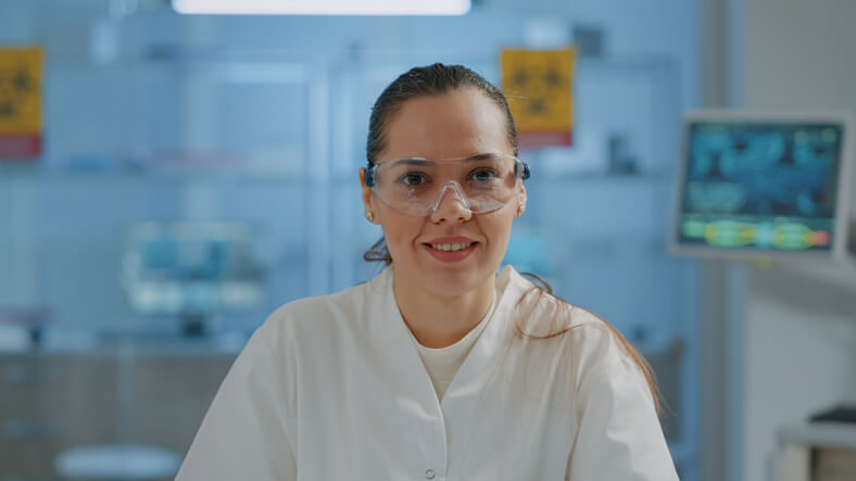 A portrait of a microbiologist wearing protective goggles in a laboratory after food safety training