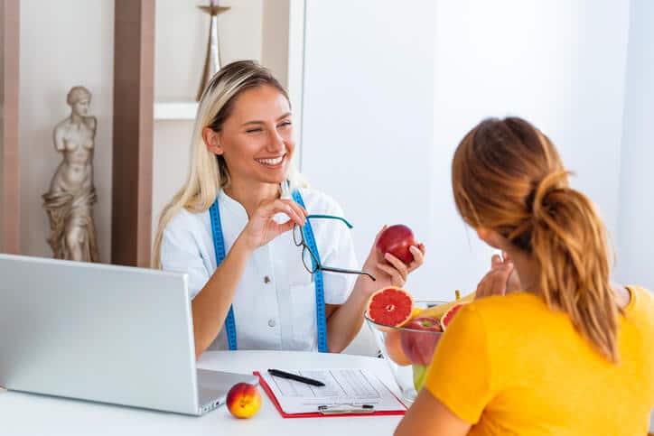 A female nutrition consultant consulting with a female patient after attaining her Diploma in Nutrition