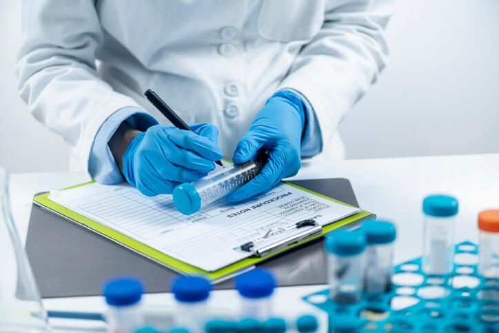 A focused male pharma QA professional handling sample preparation for pesticide testing in a laboratory