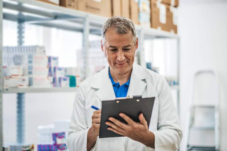 QA professional using a clipboard to record the temperature after pharma QA training