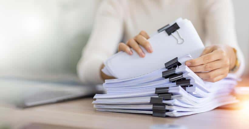 A quality assurance professional looking at audit documents after her quality assurance training