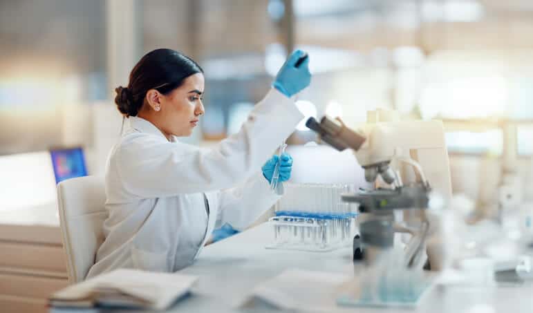 A focused female pharmaceutical professional in a laboratory after completing her pharmaceutical training