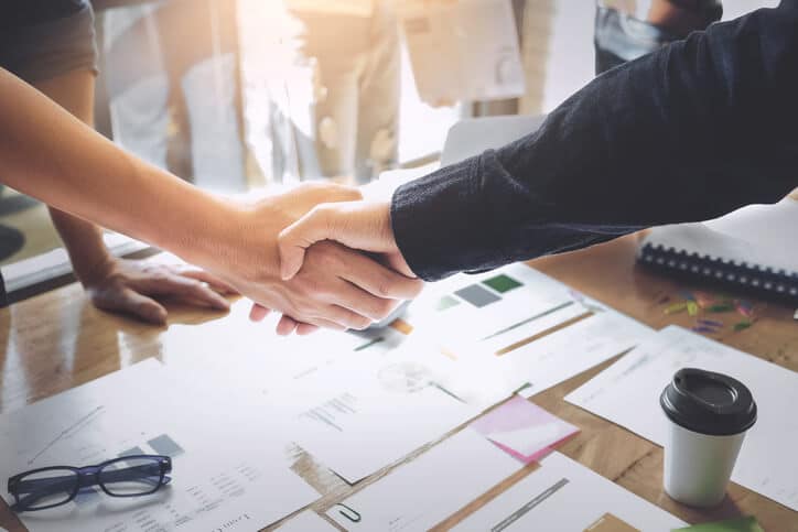 An image of someone shaking hands with a member of our student services team during his quality assurance training