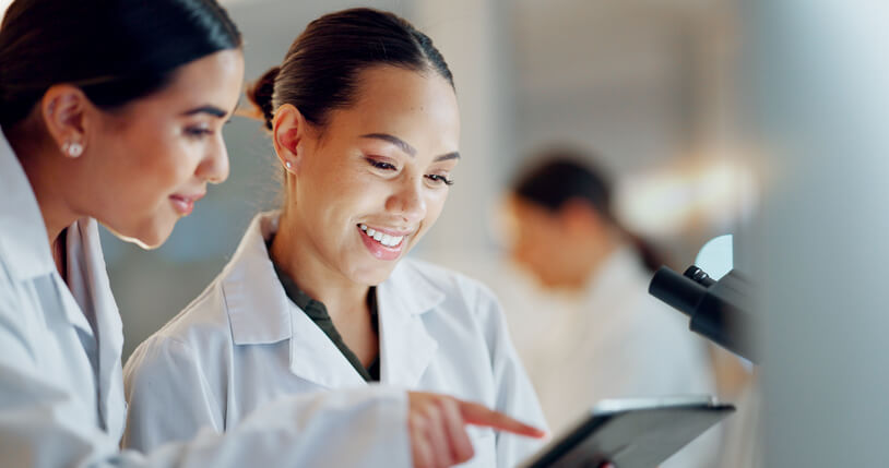 Clinical research professionals checking regulation compliance on a tablet as learned at our pharmaceutical institute