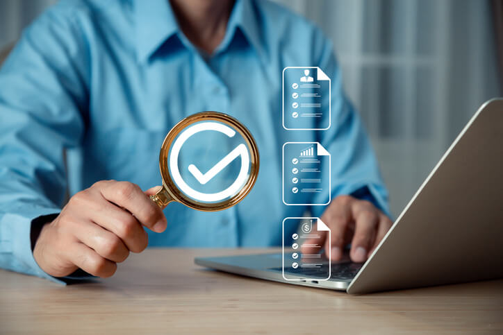 A QA professional checking documents on his laptop after completing his quality assurance training