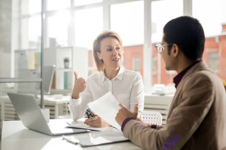 A female quality assurance Associate interacting with a pharmaceutical professional during a meeting at a manufacturing factory after her quality assurance training