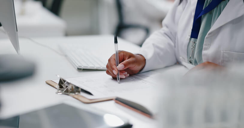 A pharma QA professional noting further specifications about some samples in a laboratory