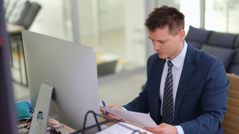 A male quality control specialist inspecting document processes after completing his quality assurance training